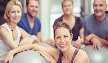 Group of patients smiling during a physical therapy or rehabilitation session